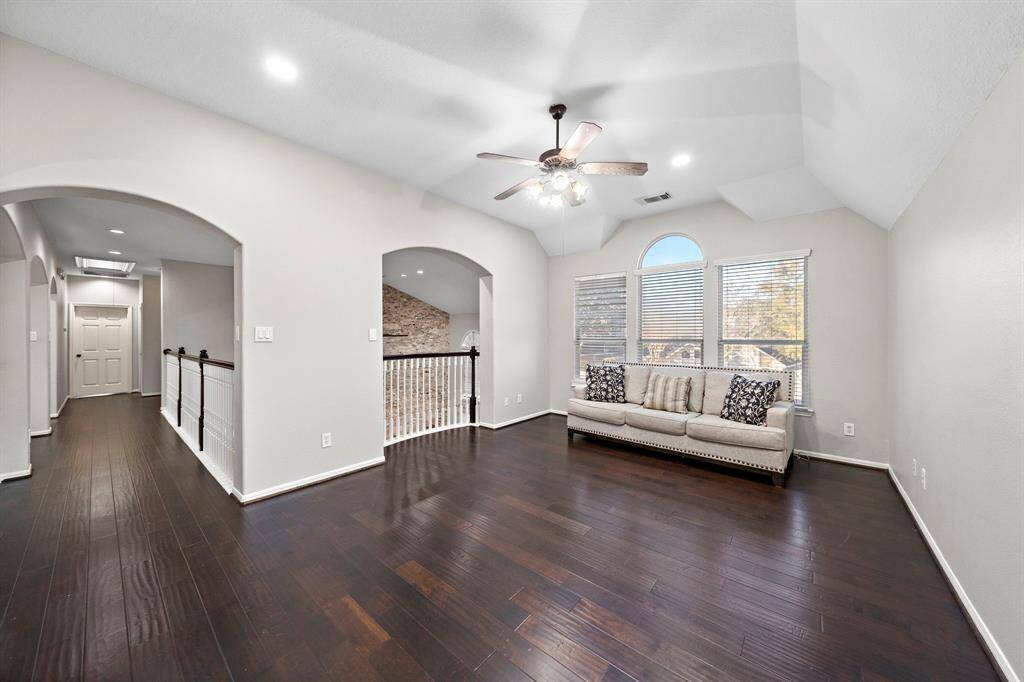 This expansive loft area is perfect for relaxation or additional living space. Oversized windows provide abundant natural light, while an open railing overlooks the living room below.