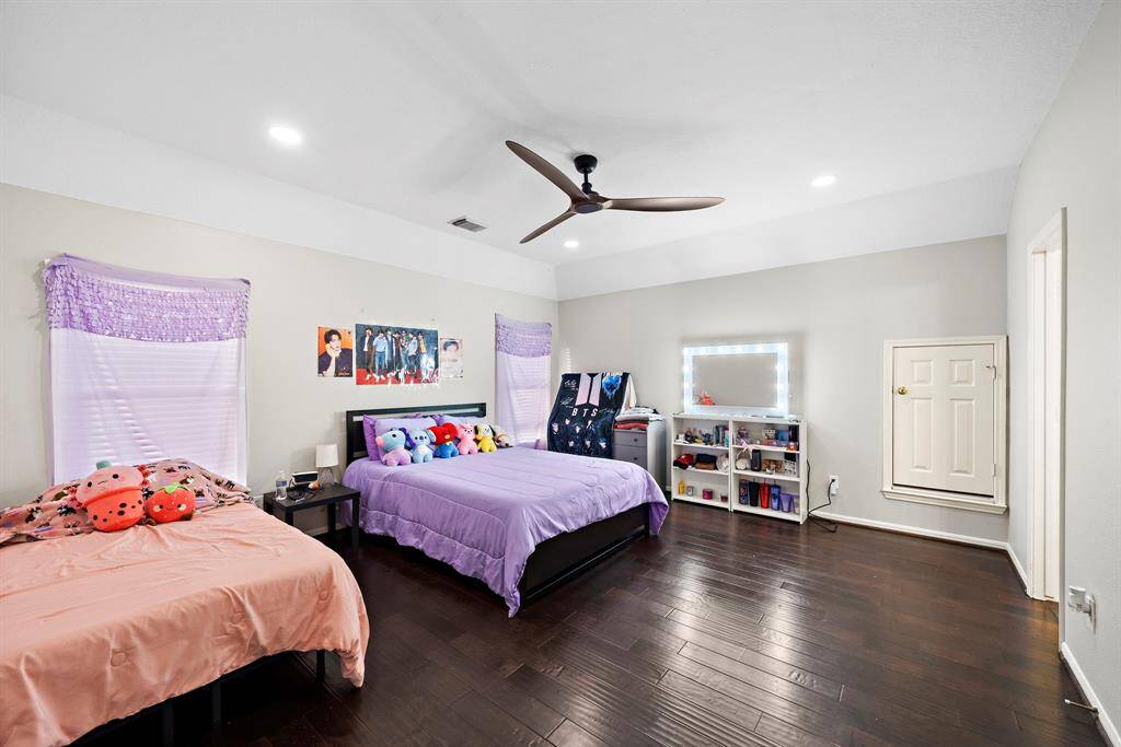 A spacious secondary bedroom with modern ceiling fans and ample natural light, offering comfort and tranquility for any guest or family member.