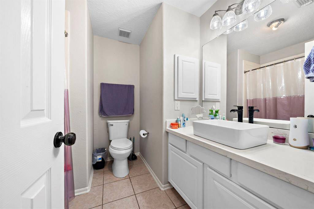 This stylish bathroom features a framed mirror and a contemporary bowl sink, combining functionality with sleek, modern design.