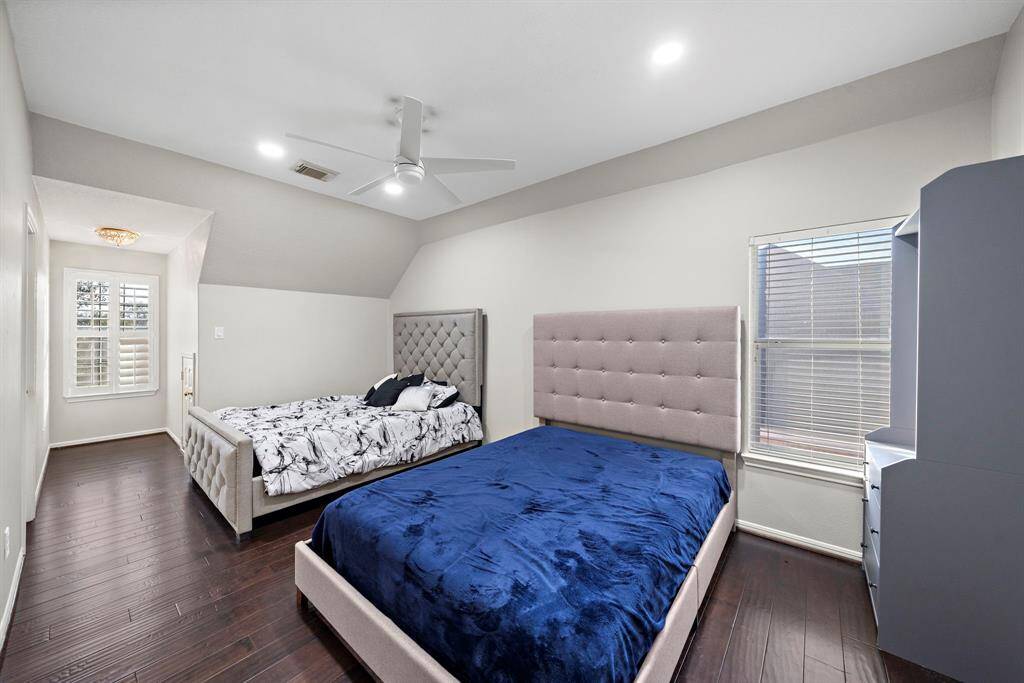 This cozy bedroom boasts plantation shutters and a serene ambiance, perfect for unwinding after a long day. The soft lighting adds to its inviting charm.