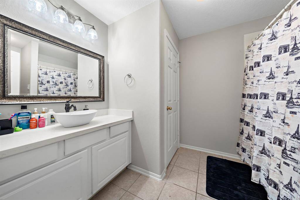 A thoughtfully designed bathroom with a dual vanity and abundant counter space. The adjoining shower area provides convenience and privacy.