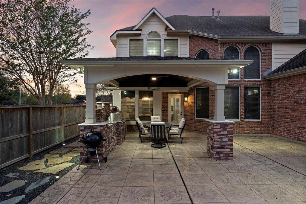The covered patio offers a seamless indoor-outdoor living experience, complete with a built-in grill and outdoor kitchen for all your culinary adventures.