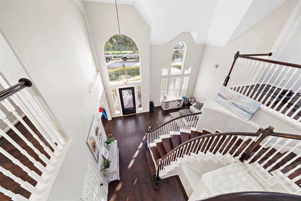 A dramatic curved staircase enhances the elegance of this grand foyer, complemented by tall windows that flood the space with natural light. The open design creates a welcoming first impression.