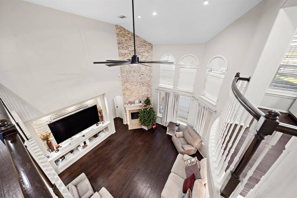 The grand open layout extends to the second-floor balcony, offering a dramatic view of the living room and highlighting the home’s exceptional craftsmanship.