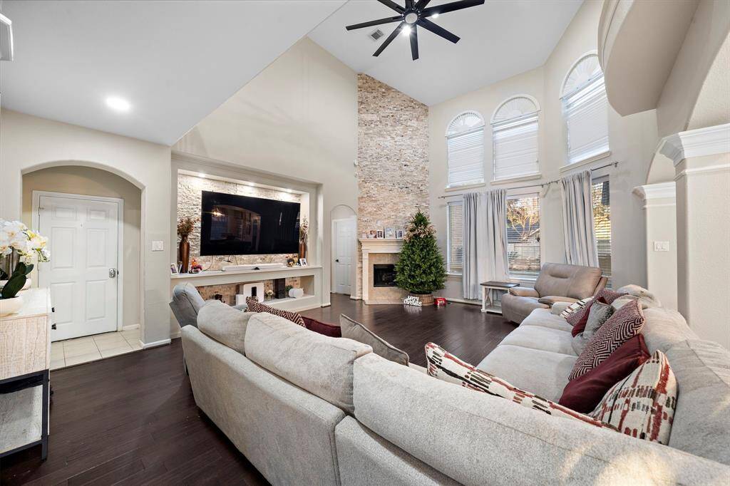 A stunning stone fireplace serves as the centerpiece of this inviting living room, adding warmth and character. The built-in entertainment niche provides a modern and functional touch.