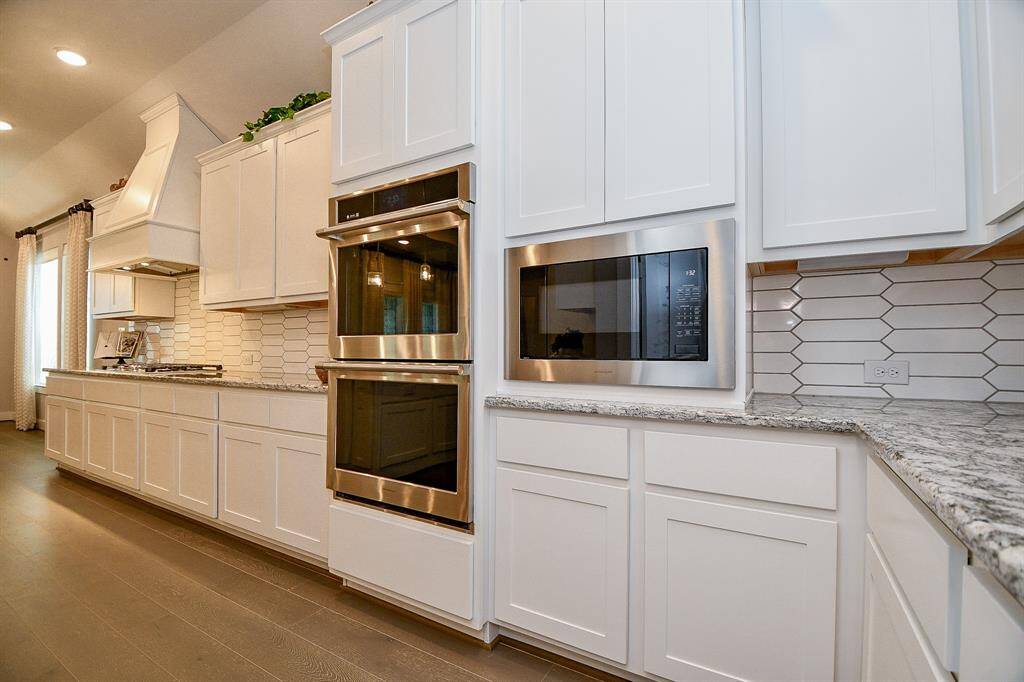 The kitchen contains high-end GE monogram appliances including gas cooktop and double ovens