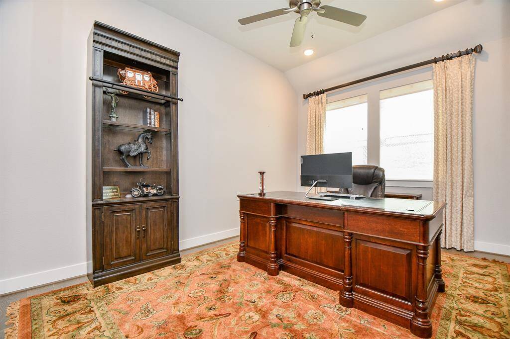The office is large with plenty of room for an oversized desk, and several bookcases.