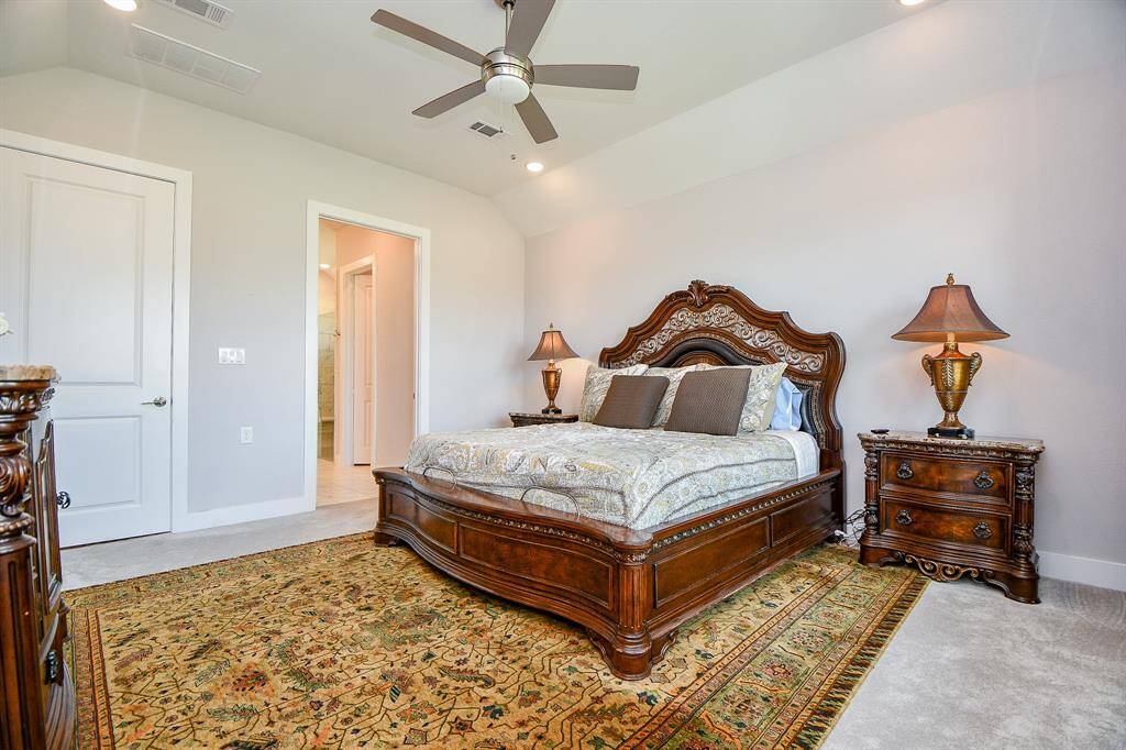 The Spacious primary bedroom features high ceilings with can lighting as well as a ceiling fan.