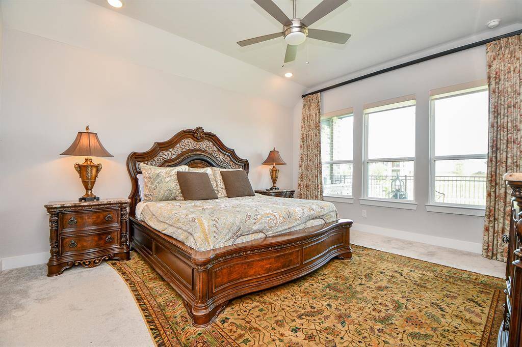 Wake up to lake views from the expansive windows in this serene primary bedroom. Natural light fills the space, creating a peaceful retreat with a stunning waterfront backdrop