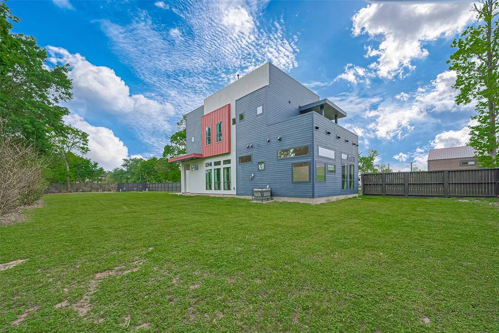 Standing at the back fence, looking toward the front of the property. You can see your 2nd floor roof top patio and another angle of the modern exterior!