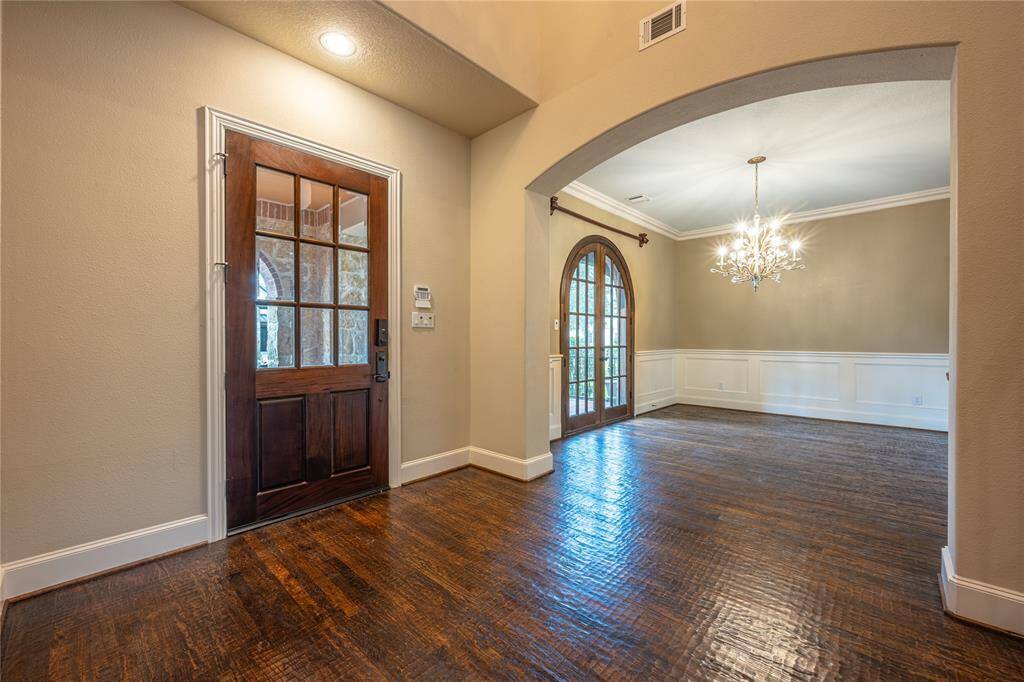 Just off the entry, the 12x16 dining room offers a refined space for gatherings, featuring hand-scraped hardwood floors that flow seamlessly throughout the home, adding warmth and elegance to the design.