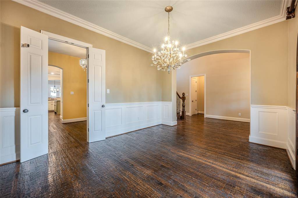 A stunning hammered champagne gold and crystal bud chandelier serves as a dazzling focal point. The room also features a double door egress to the butler’s pantry, ensuring seamless entertaining and convenience.