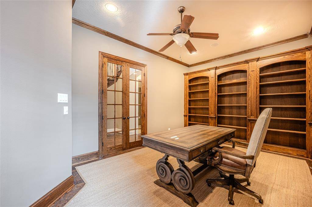 The 12x19' study is a spacious and inviting room featuring built-in bookcases for ample storage and display. A ceiling fan with light kit ensures comfort, while plantation shutters provide both privacy and natural light, creating the perfect environment for work.