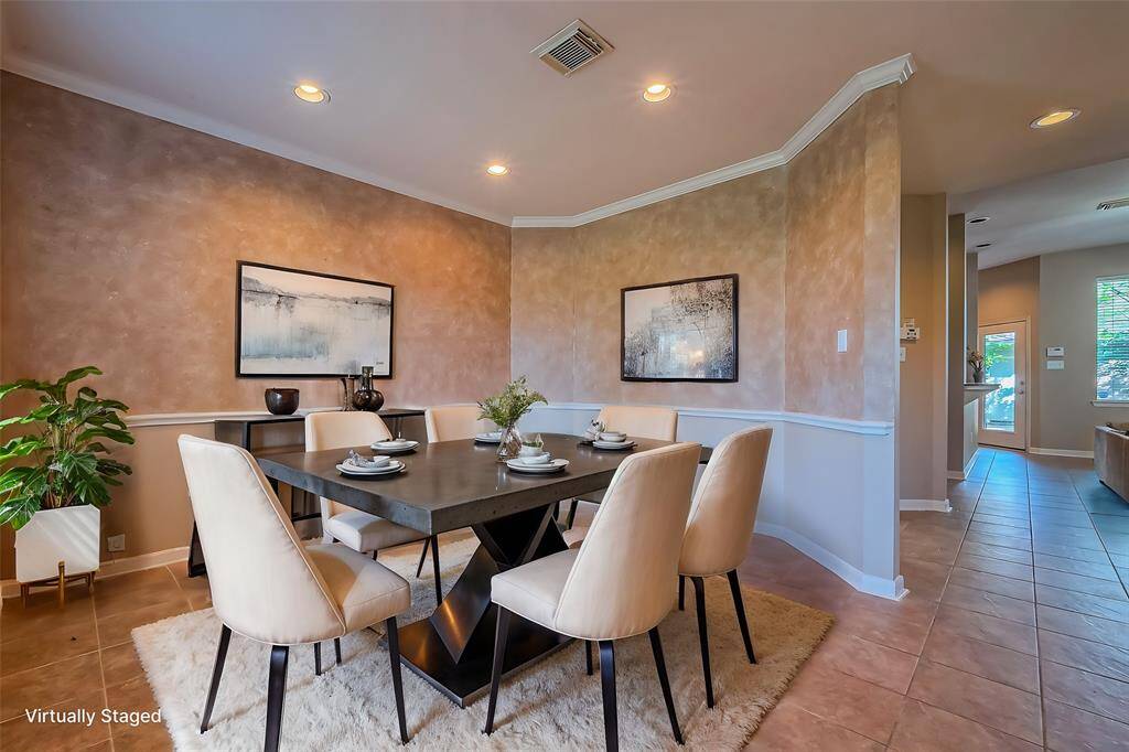 This photo showcases virtually staging of the dining room.  The walls have a warm, textured finish, complemented with recessed lighting. The space is open and inviting, with a view leading into the adjacent areas.
