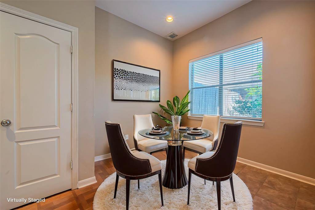 Bright breakfast nook with large window overlooking serene courtyard. Features natural light, and charming courtyard and garden views.