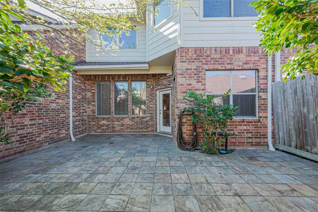 Private fenced courtyard with a stone deck, perfect for outdoor living, grilling, and entertaining. Direct access to garage.