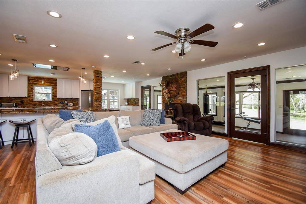 Here’s another view of the living room. Notice the two beautiful glass doors that lead to the sunroom, offering plenty of natural light. You can also spot the Lopi wood-burning fireplace, designed to heat the entire home while doubling as a cast iron stove for added warmth and charm.