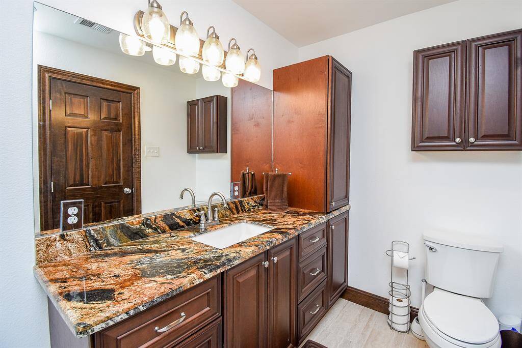 The secondary bathroom, located just outside the two guest bedrooms, is a delightful feature for your guests. The same beautiful countertop is featured throughout the home, creating a seamless flow.
