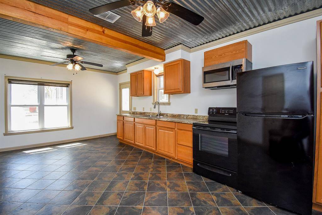 One more view of this kitchen area. Notice the cute kitchen sink window and cabinet storage. Just to the right of the refrigerator is a small pantry cabinet.