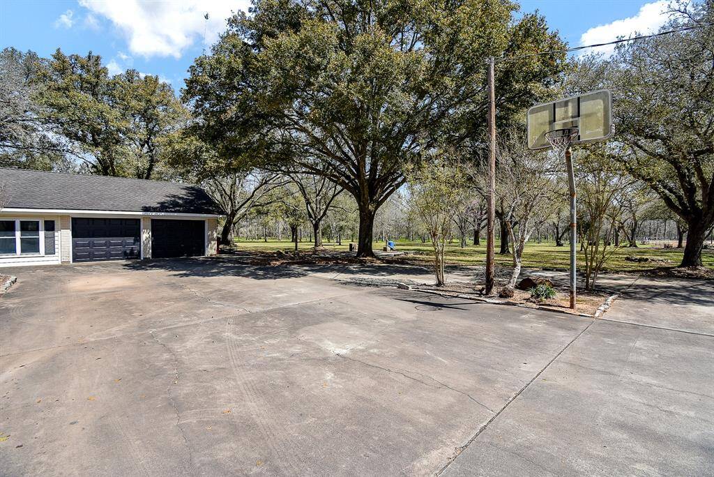 From this angle, you can see the circle drive around the built-in basketball goal, allowing for easy access to turn your car around. You’ll also catch a glimpse of some of the stunning, park-like views this property has to offer.