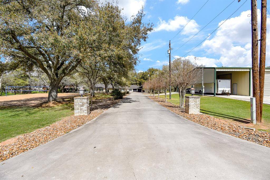 Here’s a view of the property from the street, showcasing the long driveway. Closer to the home, there’s a circular section, making it easy to turn around. The driveway also widens near the garage, providing ample space for double parking.