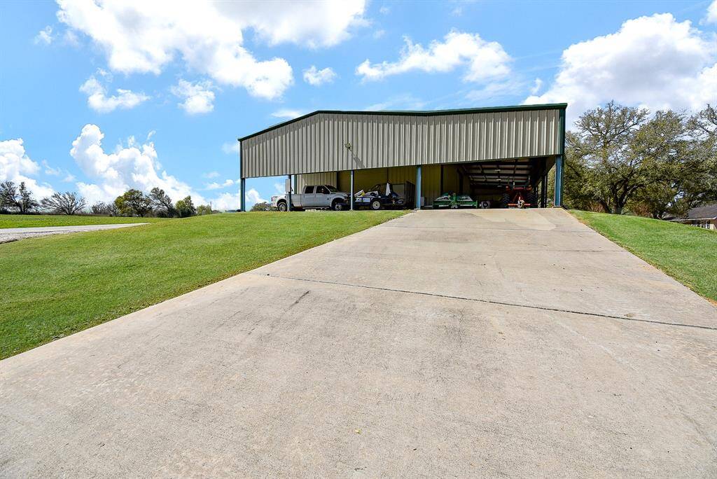 Here’s a view of one side with driveway access. The shop itself spans 4,800 square feet without the awnings and features 5 roll-up doors, each measuring 14' x 14', providing added convenience for easy entry and exit.