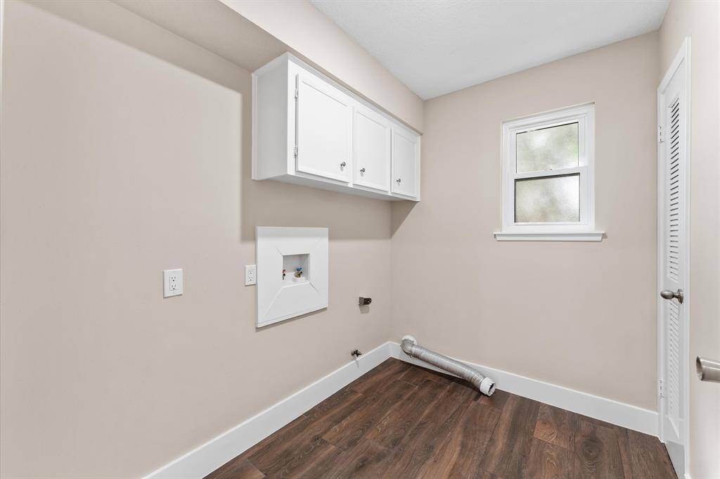 The Updated UTILITY ROOM Features Porcelain Wood Look Flooring w/Added Floor Drainage, Custom Paint, Recessed Lighting, New Window, Hot Water Heater (2018) Prepped for both Electric or Gas Dryer, Extra Cabinets & Room for Fridge or Freezer!