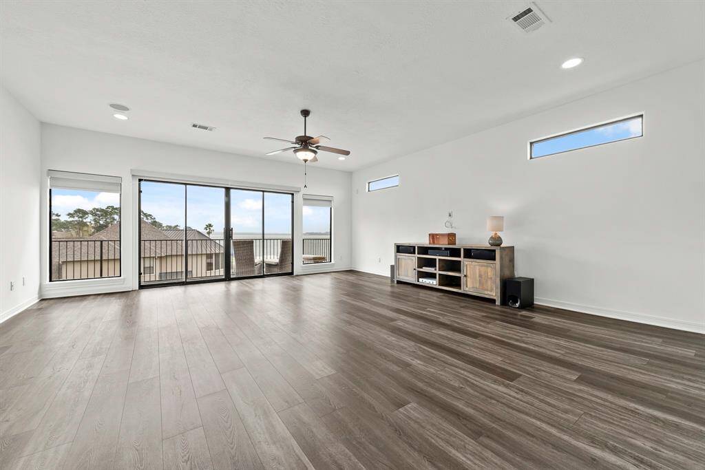 Large game room on third level with sliding doors to waterfront balcony