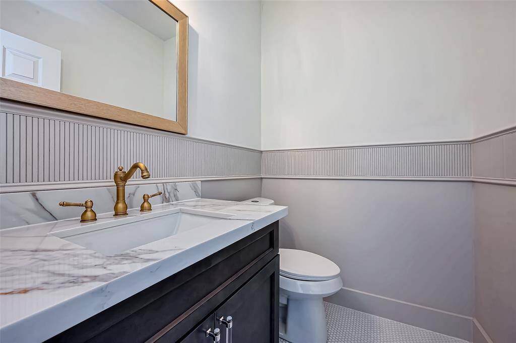 The powder room is beautifully designed with custom paneling and vanity.