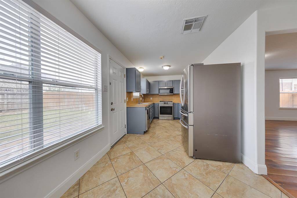 The kitchen is a bright, welcoming space where sunlight and fresh coffee make morning routines effortless and enjoyable.