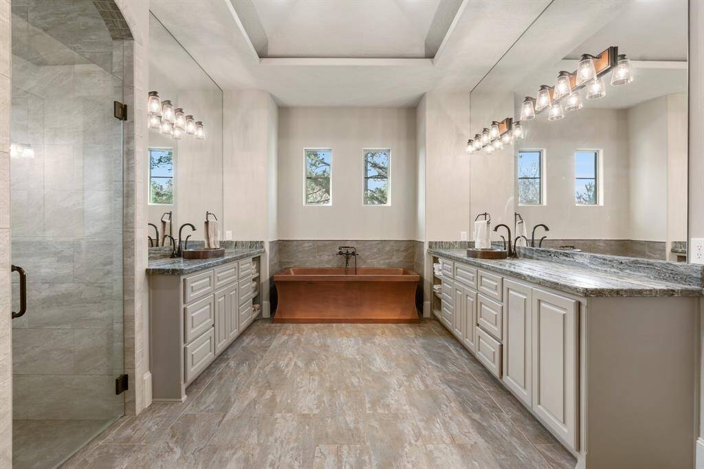 Luxury bath with copper soaking tub, dual vanities and 2 large walk in closets.