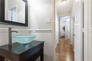 Convenient first floor half-bathroom is perfect for guests, and features a dark walnut vanity with black granite countertop and glass vessel sink.