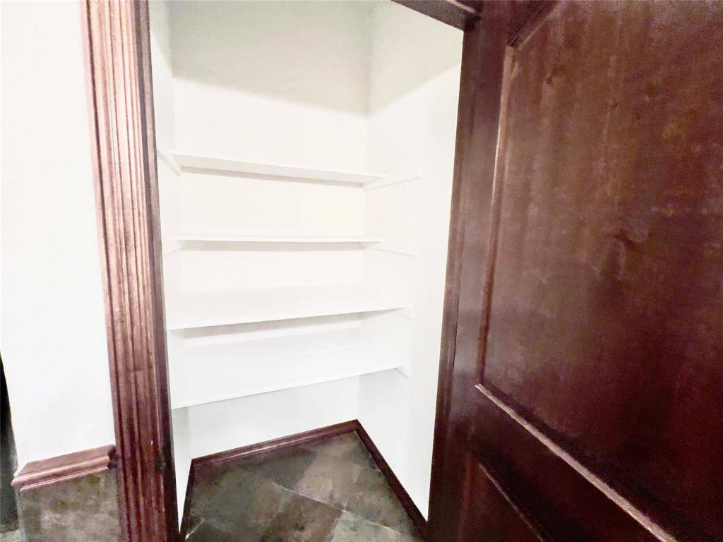 This is a storage nook with built-in white shelves, set against a dark wood backdrop, providing a practical space for organization.
