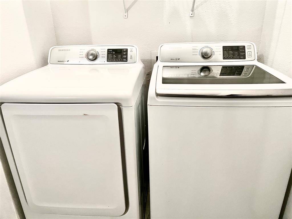 The photo shows a modern laundry setup with a matching Samsung washer and dryer in a clean, white finish, offering a sleek and functional addition to the home.