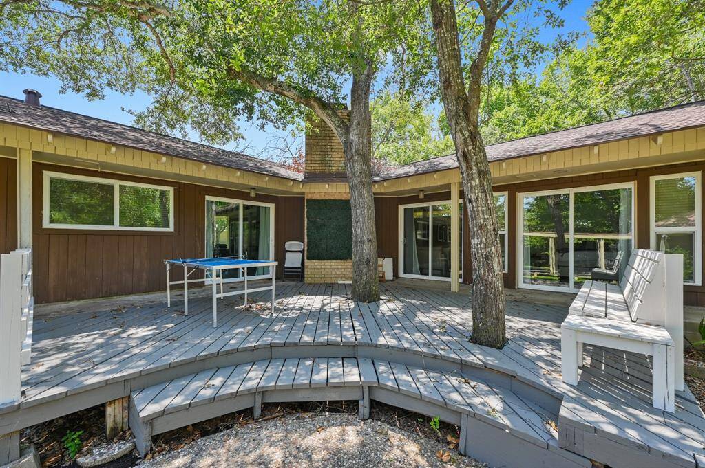 A relaxing escape, this backyard retreat boasts a spacious deck perfect for outdoor lounging or entertaining. The view extends seamlessly from the interior through sliding glass doors, blending indoor and outdoor living.
