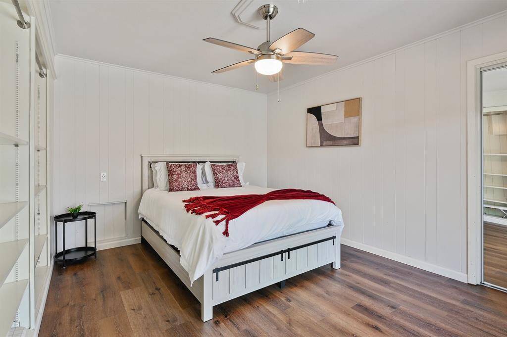 A comfortable retreat featuring a stylish ceiling fan that complements the aesthetic of the room. The same warm wood-like laminate flooring flows throughout, adding continuity and charm. A neutral palette enhances the versatility of the space.