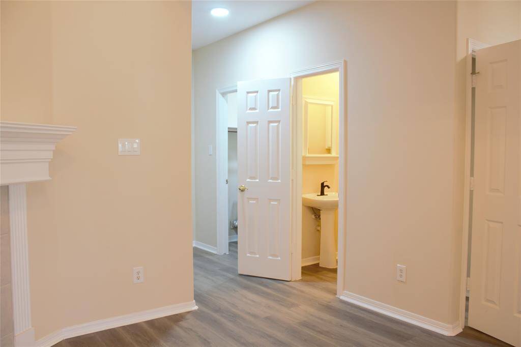 Walk way to the two car garage with the powder room and laundry to the right