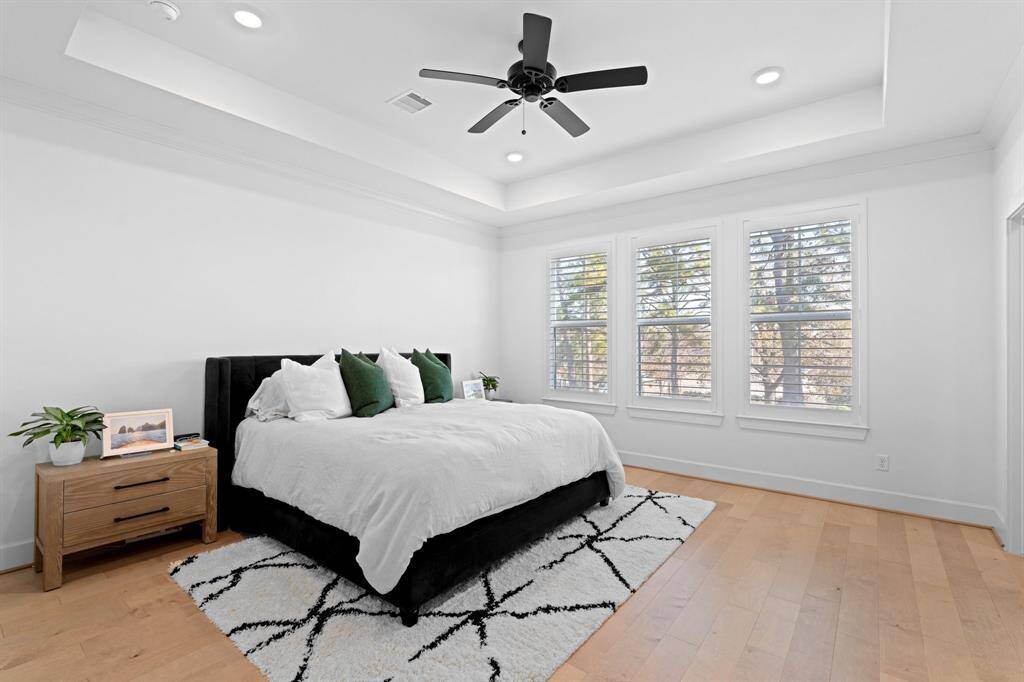 Featuring a tray ceiling and large windows this primary bedroom is a true retreat.