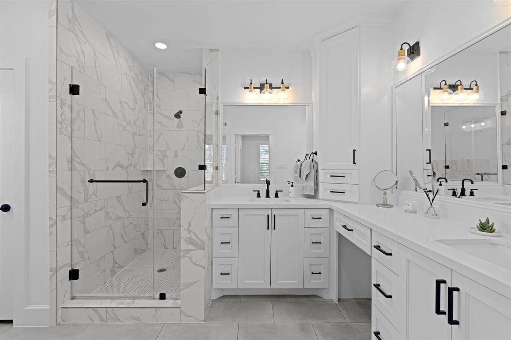 This spa like bathroom features double sinks, vanity area, soaking tub, and separate shower.