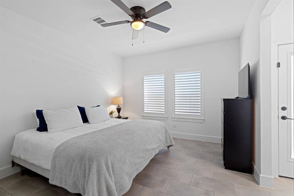 A third bedroom is conveniently situated on the first floor, complete with its own ensuite bathroom for added privacy and comfort. Enjoy access to a small outdoor patio from this bedroom. Perfect for a home office or for visiting guests.