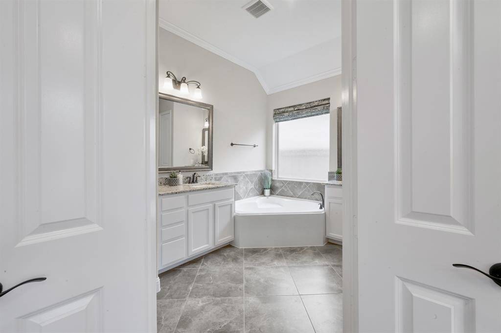 The large window in you primary bathroom suite has frosted glass for privacy, but allows for a nice amount of natural sunlight.