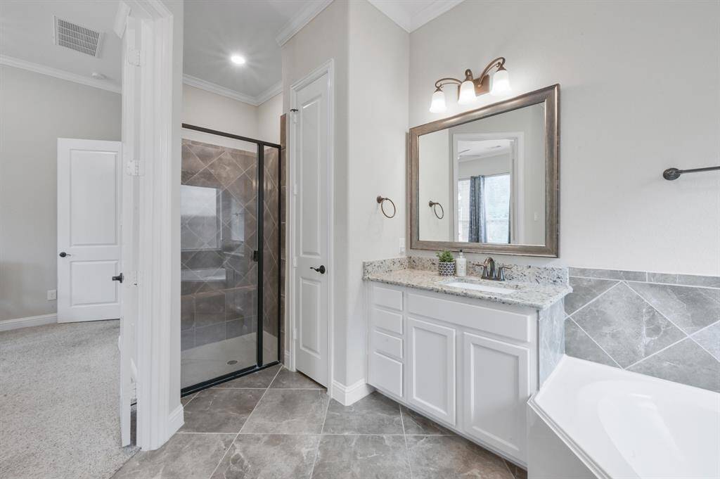 Your primary bathroom offers two SEPARATE sinks, a large soaking tub and a glassed in shower.