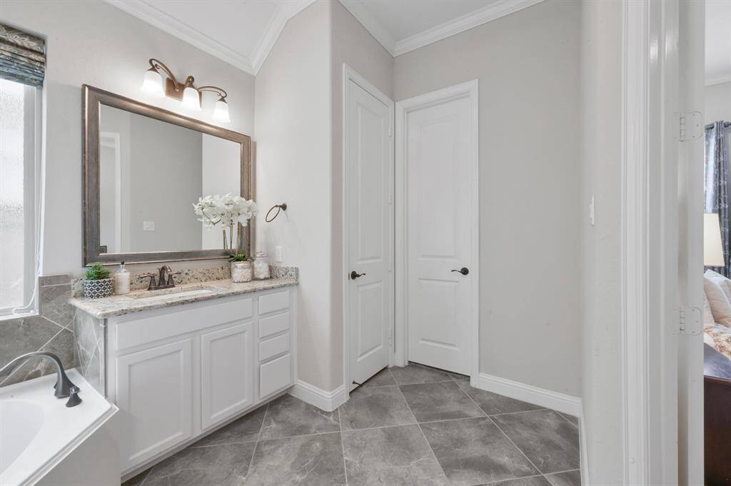 A view of the second SEPARATE bathroom vanity. Behind the doors there is a HUGE his and hers primary bedroom closet.