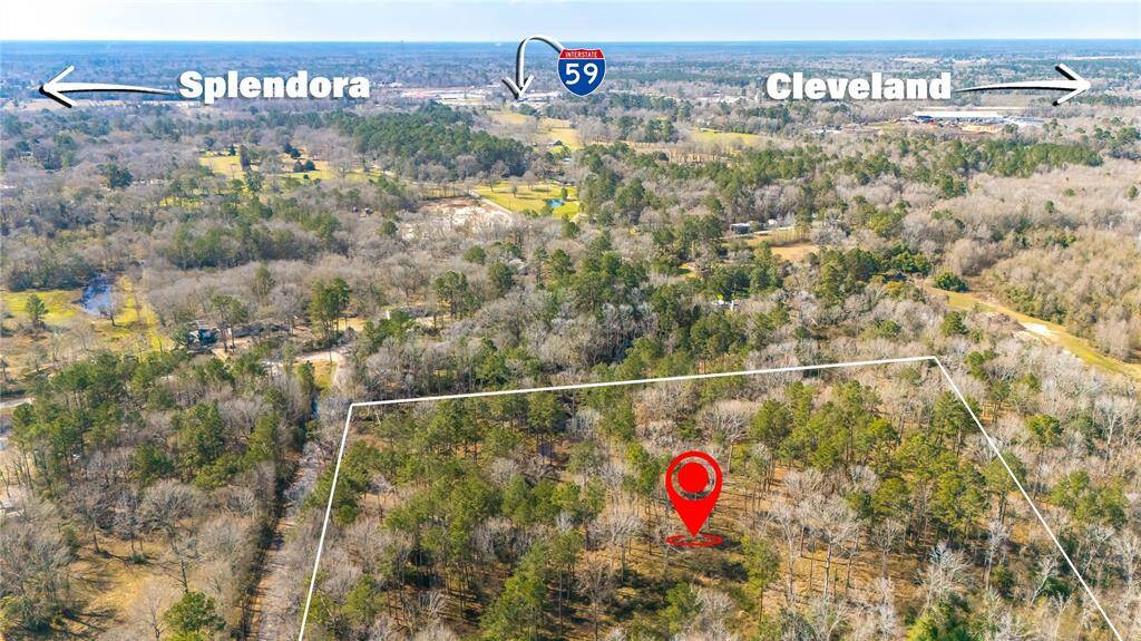 This aerial photo showcases a wooded plot of land outlined in white, located between Splendora and Cleveland, with Interstate 59 nearby. Ideal for those seeking a private, natural setting with convenient access to nearby towns.