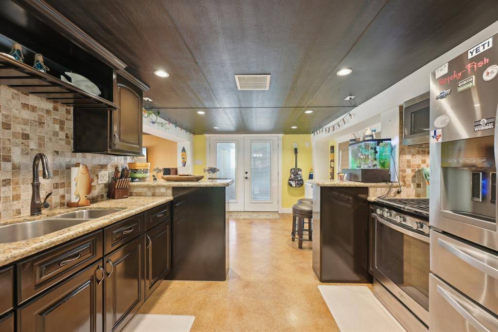 Open kitchen with stainless steel appliances and granite countertops