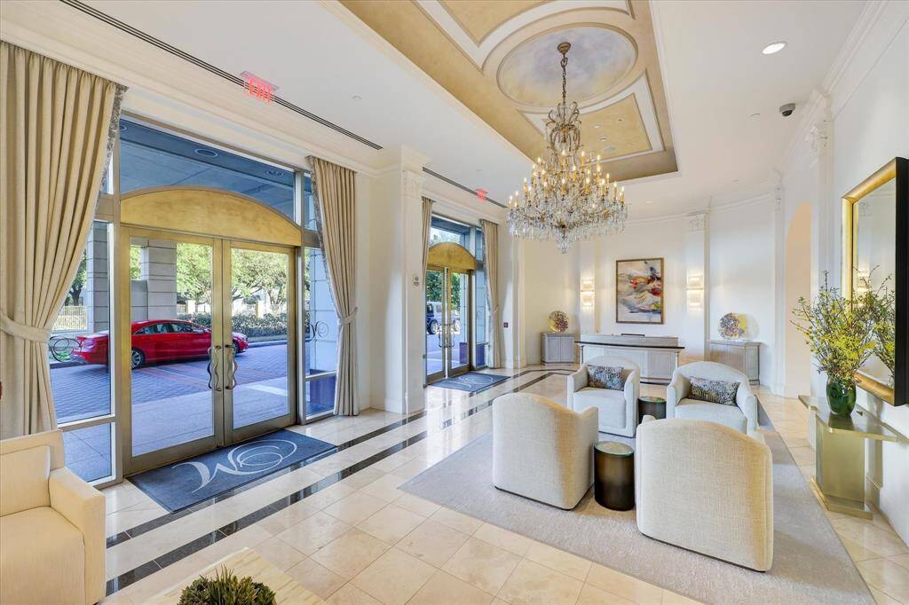The recently renovated lobby with the concierge front desk, an inviting seating area and glass doors provides views of the beautiful landscaping around the front driveway.