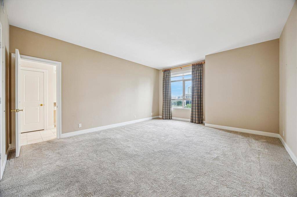 Spacious primary bedroom with natural sunlight.