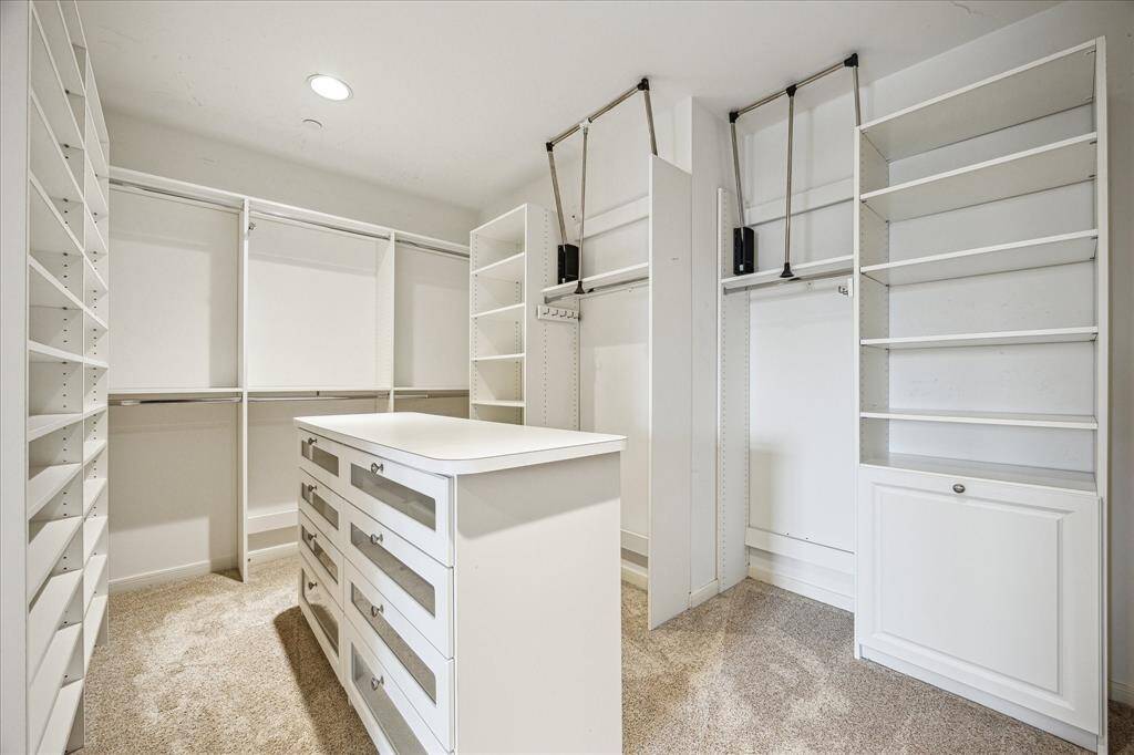 You'll have to go shopping to fill up this over-sized custom built primary closet! Shelving, lots of drawer space, pull down handles to reach the high hanging rods. What a dream!
