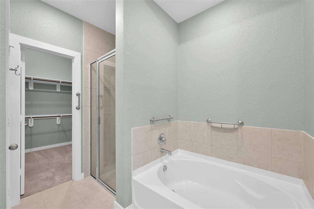 Primary bath features a separate shower and soaking tub.