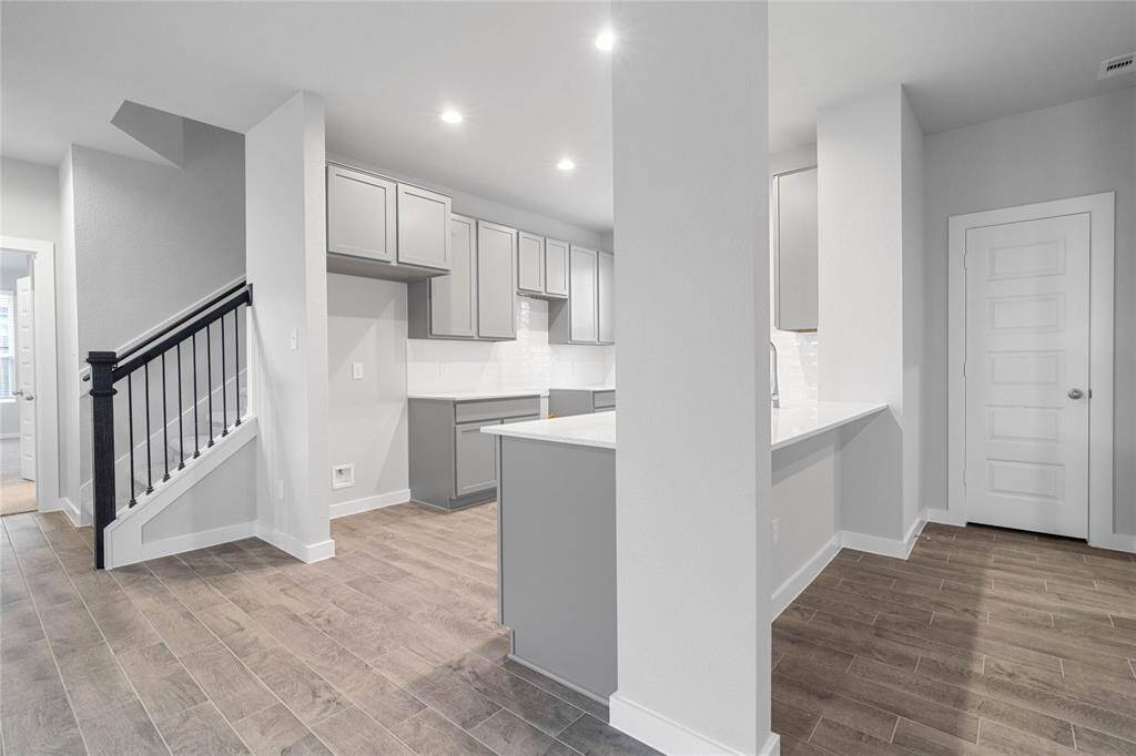 This kitchen is by far any chef’s dream! This spacious kitchen features high ceilings, stained wood cabinets, quartz countertops, SS appliances, modern tile backsplash, recessed lighting, extended counter space and breakfast bar, and a walk-in pantry.